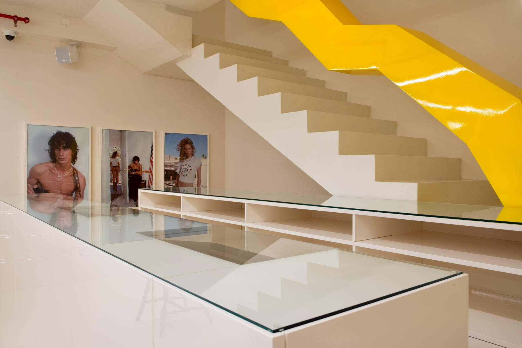 Kolab main floor with a sculptural yellow staircase and glass display cases